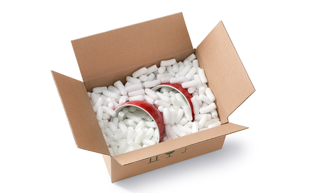 Ein Karton mit Kerzen und länglichen Bio-Verpackungschips